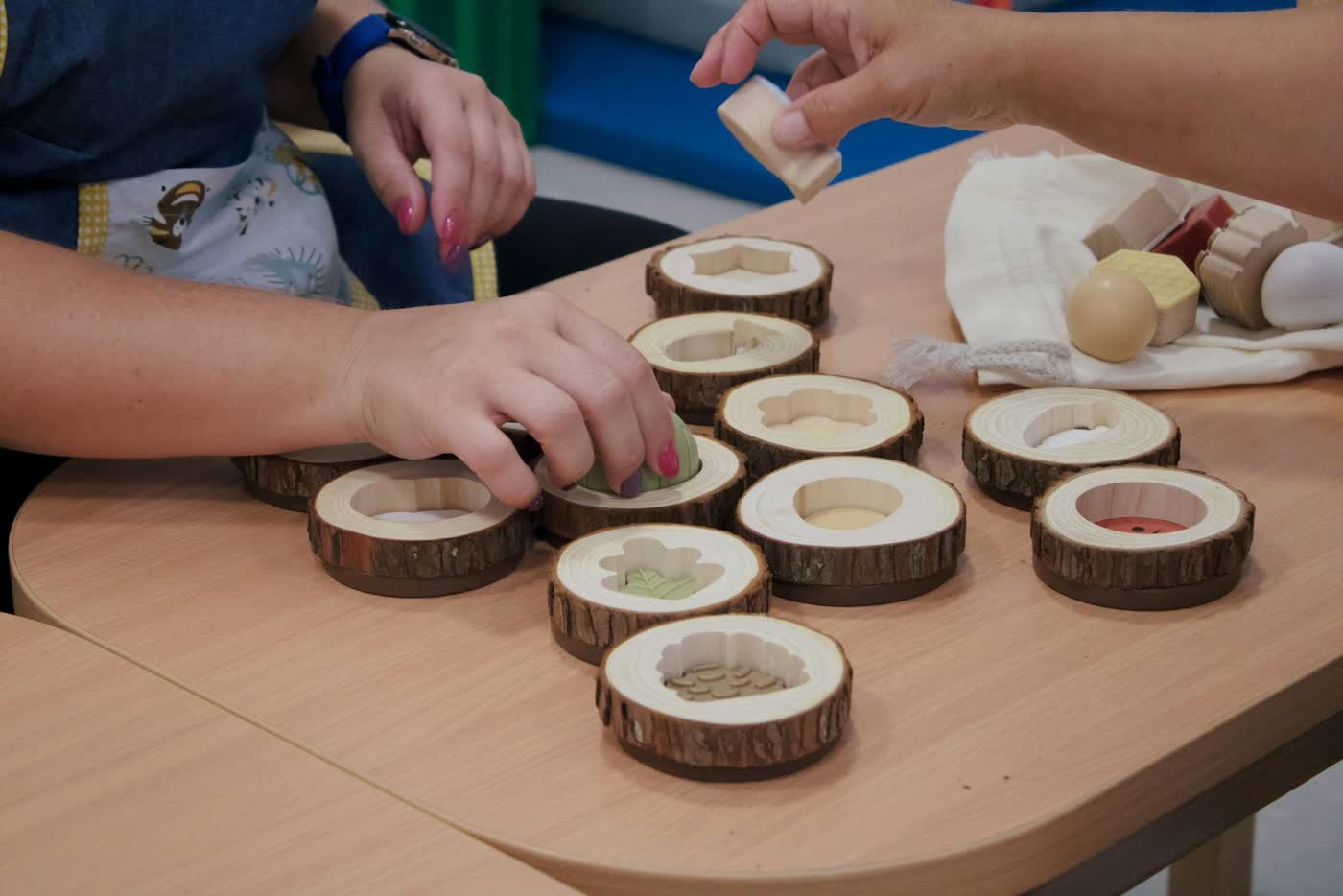Children exploring loose parts with an educator at Young Smarties
